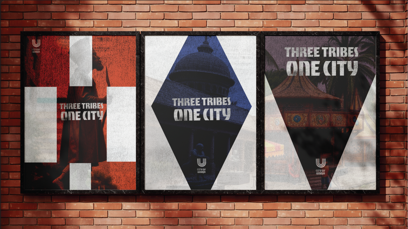 Three City of Umoja symbol posters framed on a brick wall