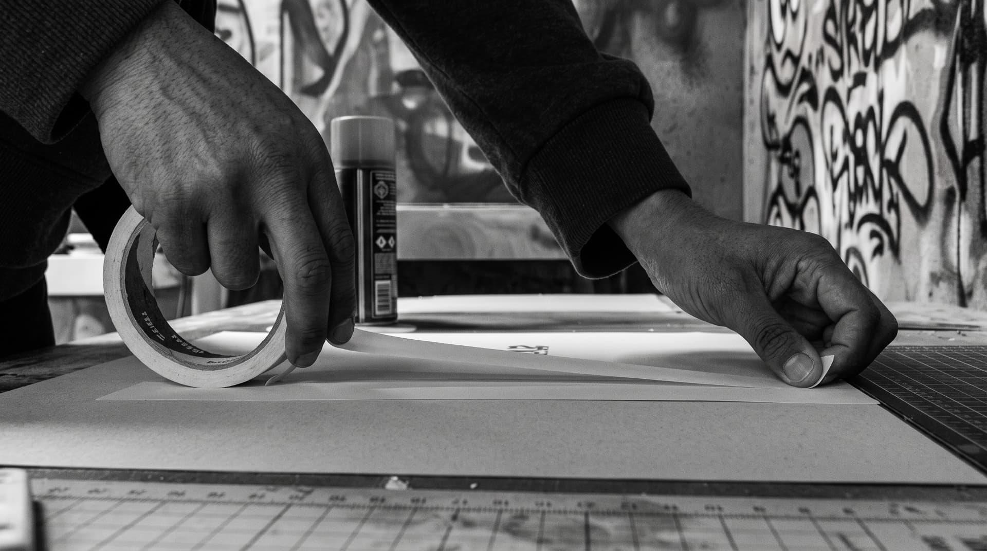 Hands trimming a printed sheet in the studio